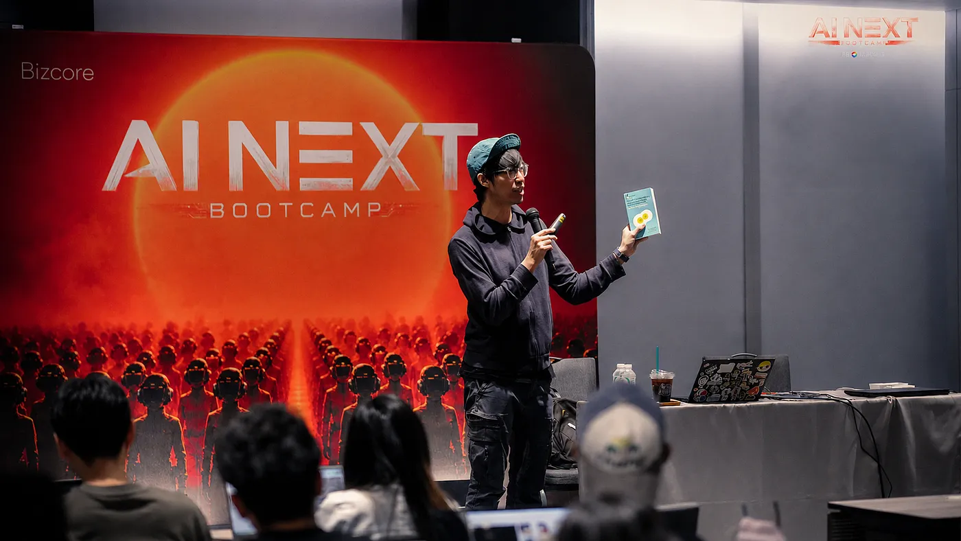 คุณทอยจาก DataRockie พูดบนเวทีและถือหนังสือหน้าเวที AI NEXT